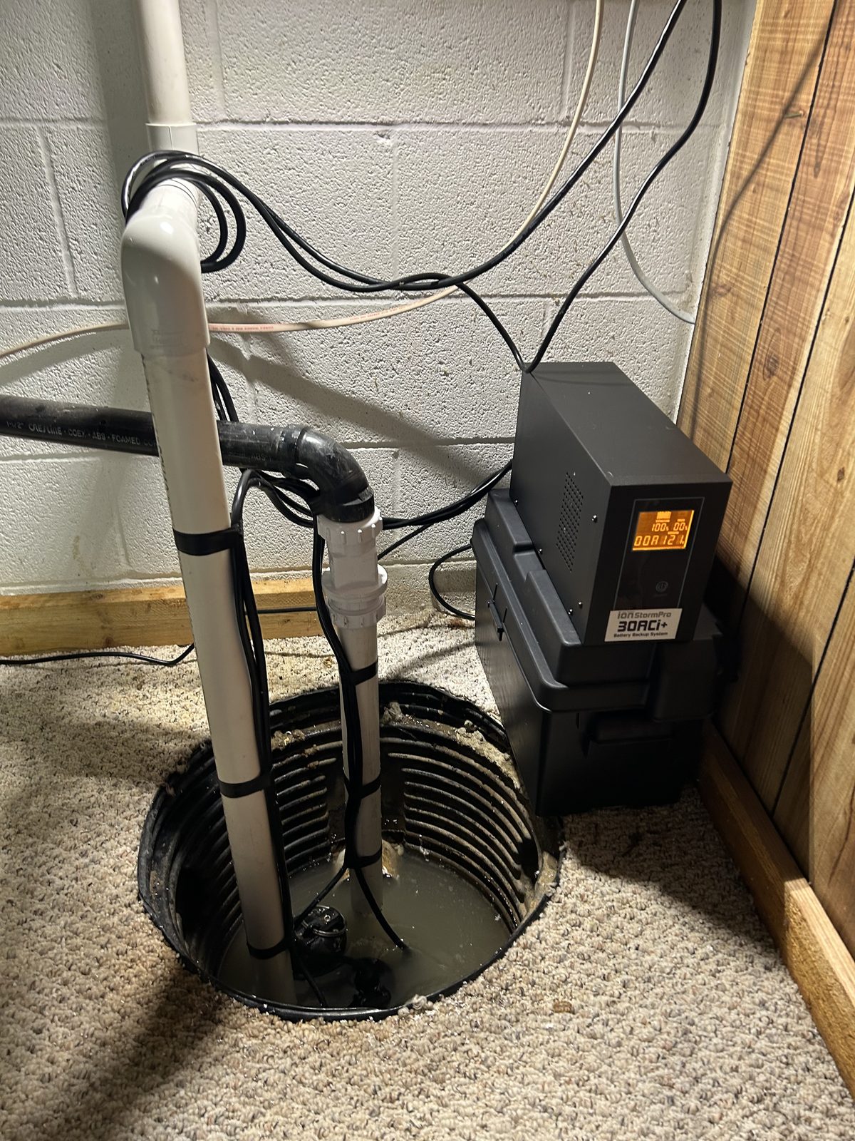 Battery backup sump pump system in a basement
