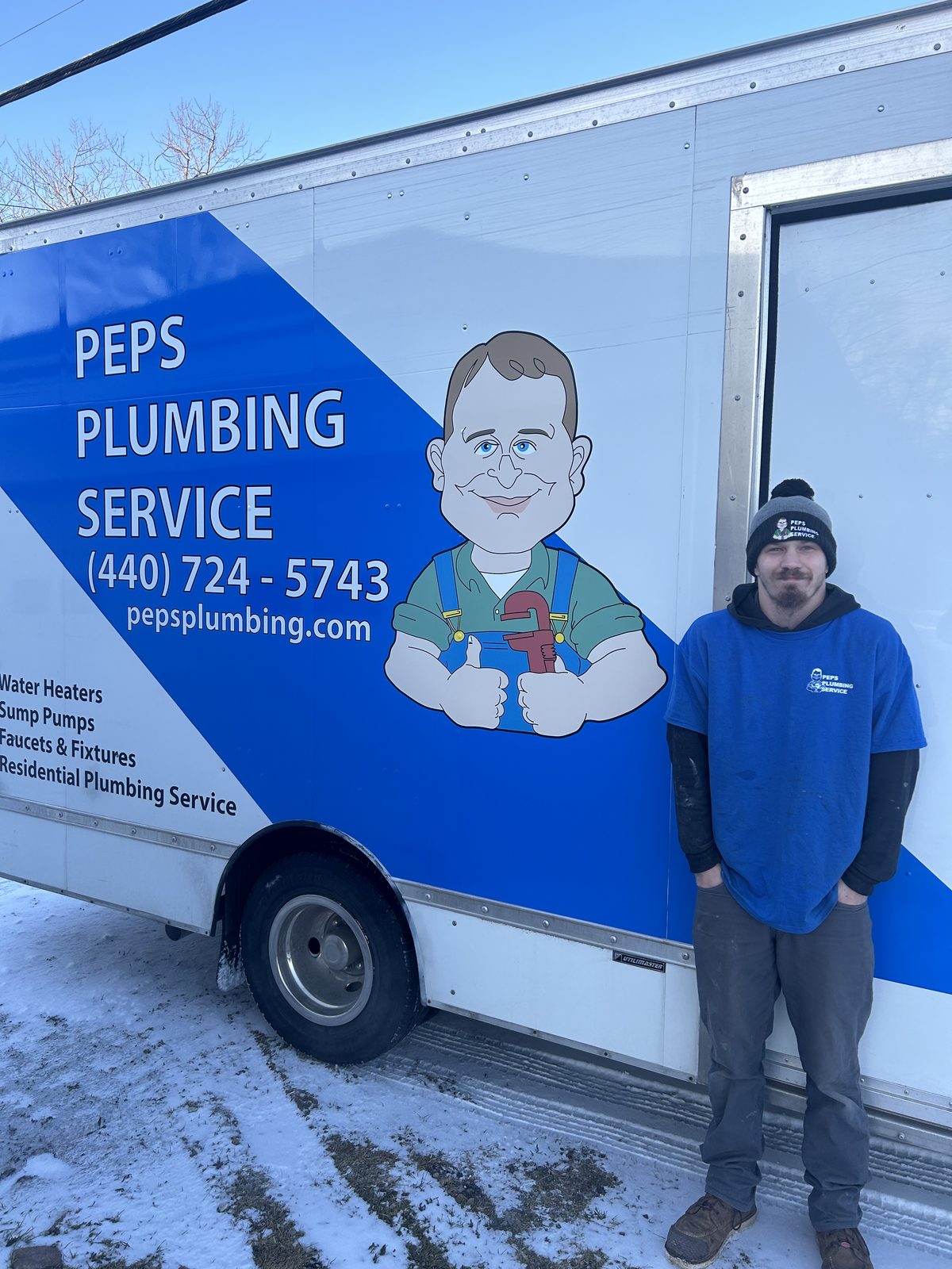 Peps Plumbing technician beside the service truck in winter